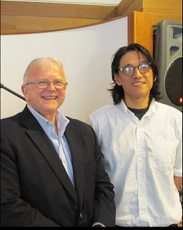 Terry Jude Miller and Li-Young Lee smile and pose for a photo in business casual attire.